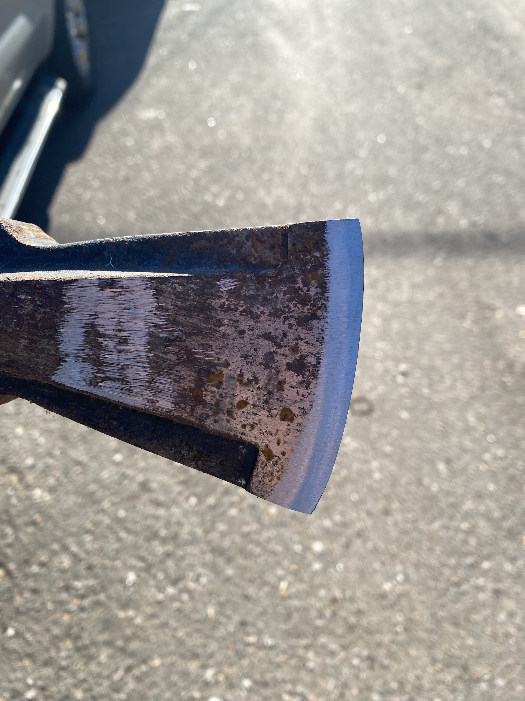A worn axe head with a newly restored cutting edge